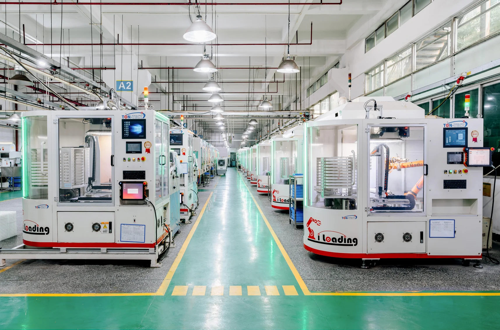 Automated production workshop with enclosed machinery and robotic loading systems